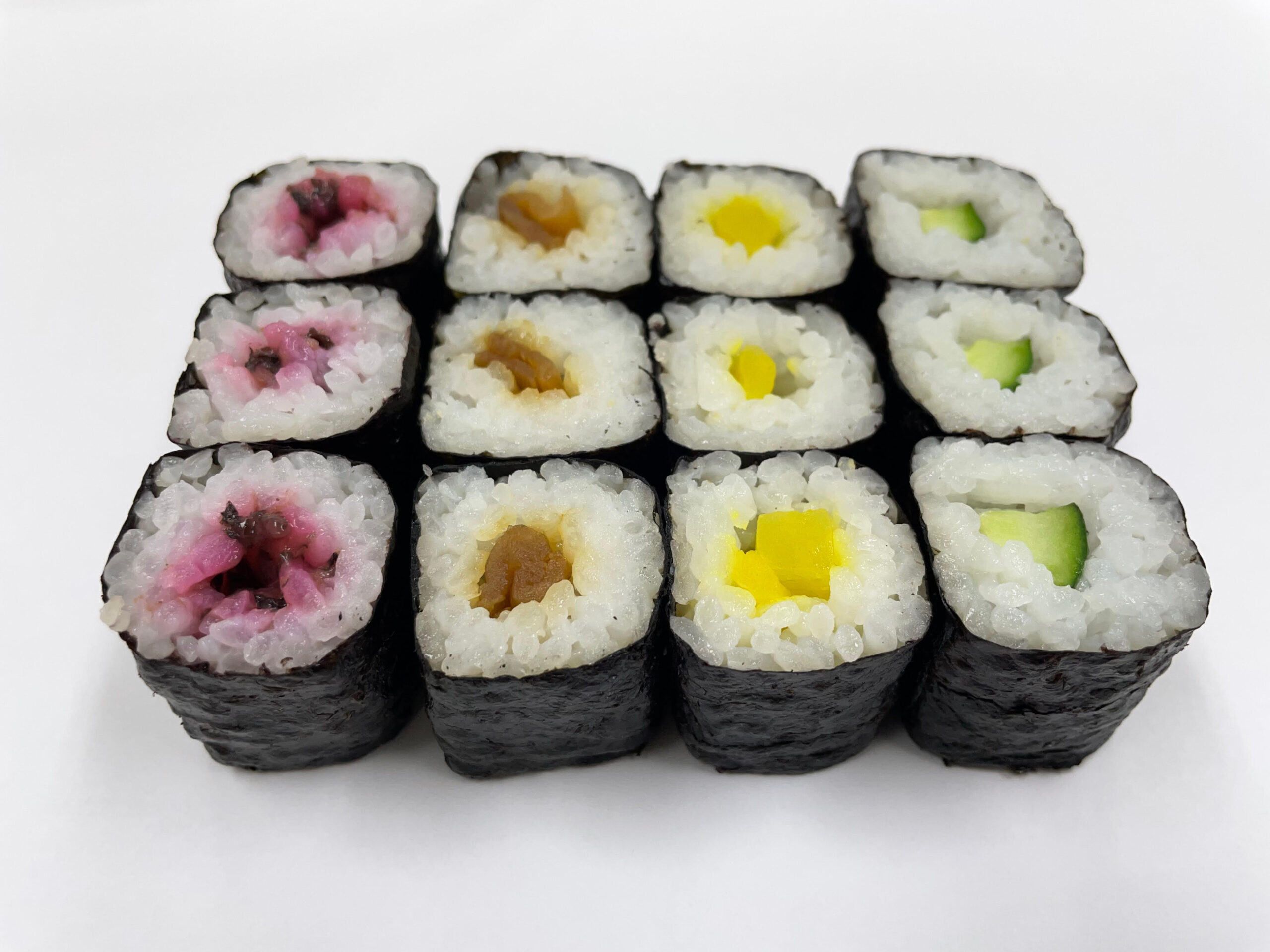 Quatro tipos de hossomaki com alga nori por fora e um recheio principal no centro