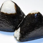Onigiri japonês em formato triangular envolvido em nori