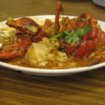 Chili Crab de Singapura: o que é, molho e receita | Comidas Asiáticas Chili crab de Singapura servido com caranguejo em molho espesso de tomate e pimenta