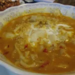 Fish amok cambojano servido em recipiente com molho cremoso de coco