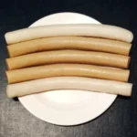 Cilindros de garaetteok branco e de trigo-sarraceno servidos em prato