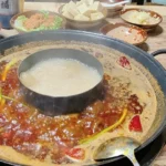 Hot pot de Sichuan com caldo vermelho picante servido à mesa