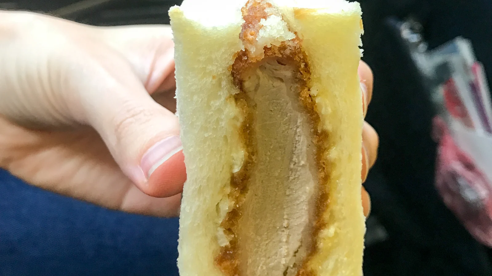 Katsu sando com costeleta suína empanada entre fatias de pão macio.