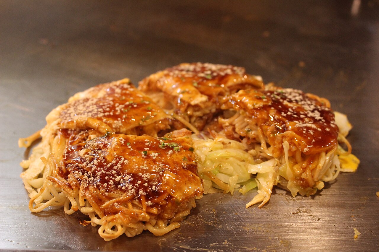 Okonomiyaki estilo Hiroshima preparado em camadas com macarrão e repolho
