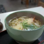 Tigela de udon japonês com caldo e tempura