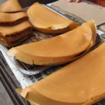 Panquecas apam balik dobradas ao meio em uma banca de rua na Malásia