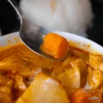 Tigela de curry vermelho tailandês com molho alaranjado de coco e vegetais