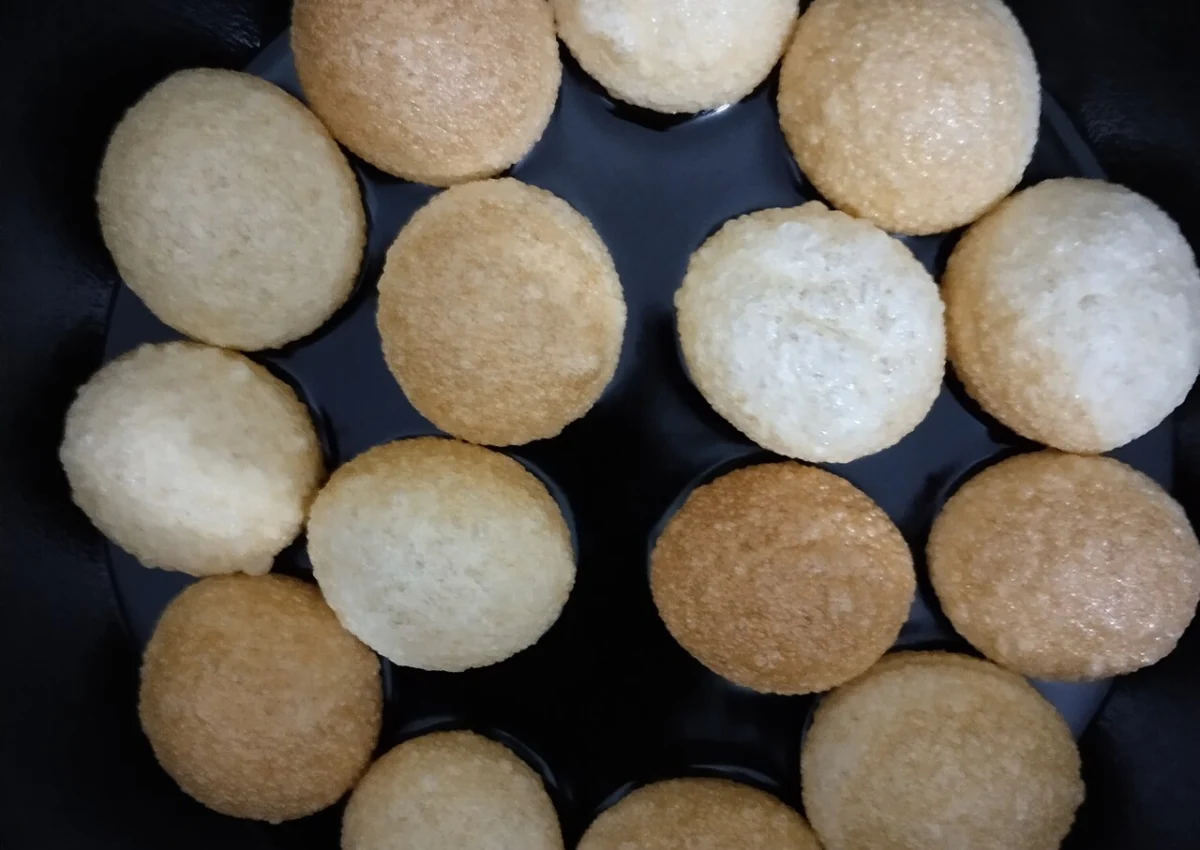 Pequenas casquinhas de puri inflando enquanto são fritas em óleo para o preparo do phuchka