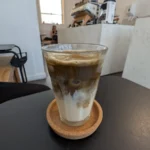 Copo de hojicha latte gelado com cor marrom clara