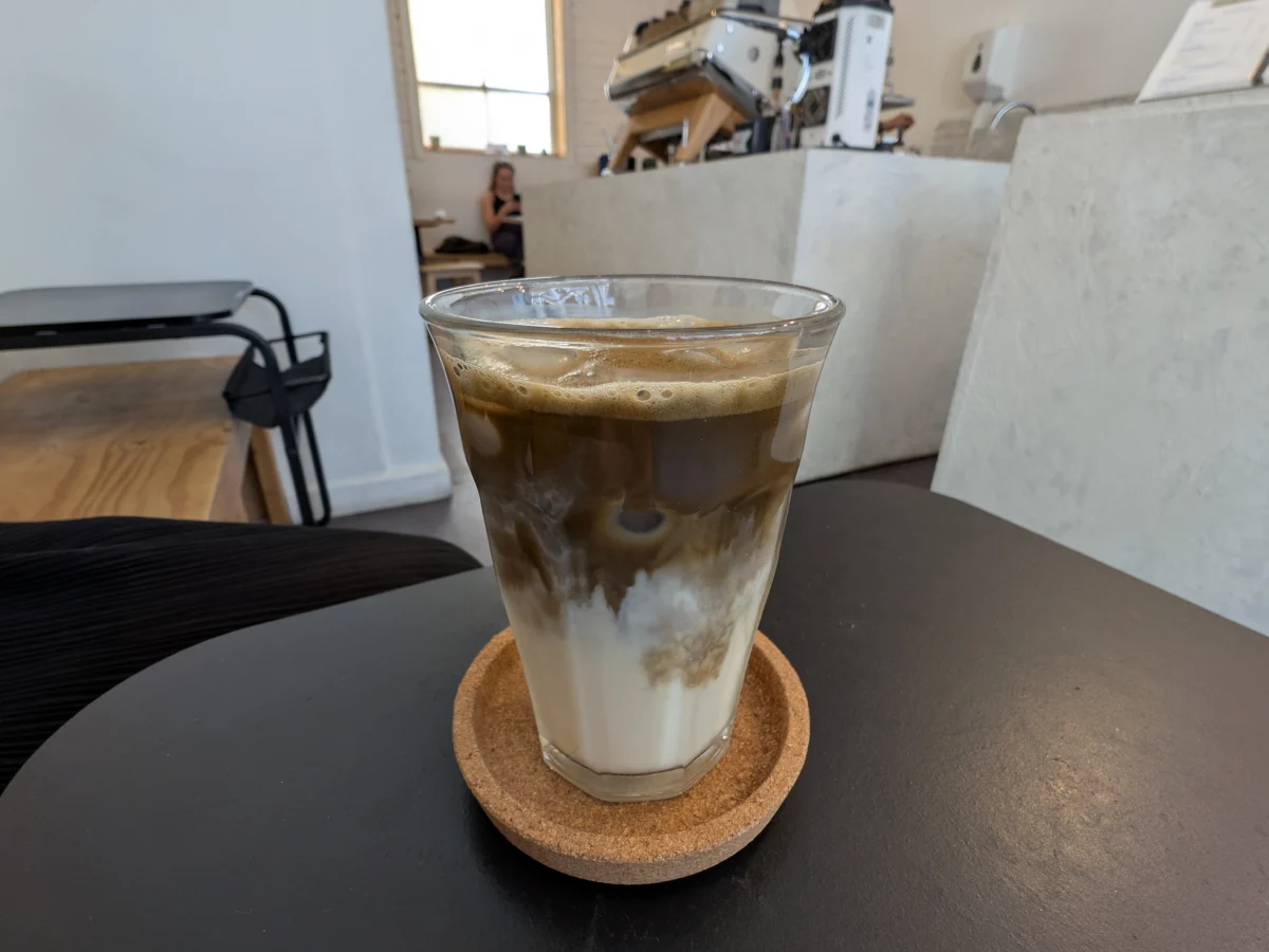 Copo de hojicha latte gelado com cor marrom clara