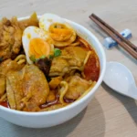 Laksa: O Que É e Como Fazer a Sopa Picante Malaia | Comidas Asiáticas: Tigela de curry laksa malaia com macarrão e caldo condimentado