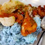 Nasi kerabu com arroz azul e acompanhamentos malaios