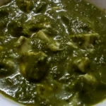Palak paneer indiano de espinafre com cubos de queijo em tigela branca