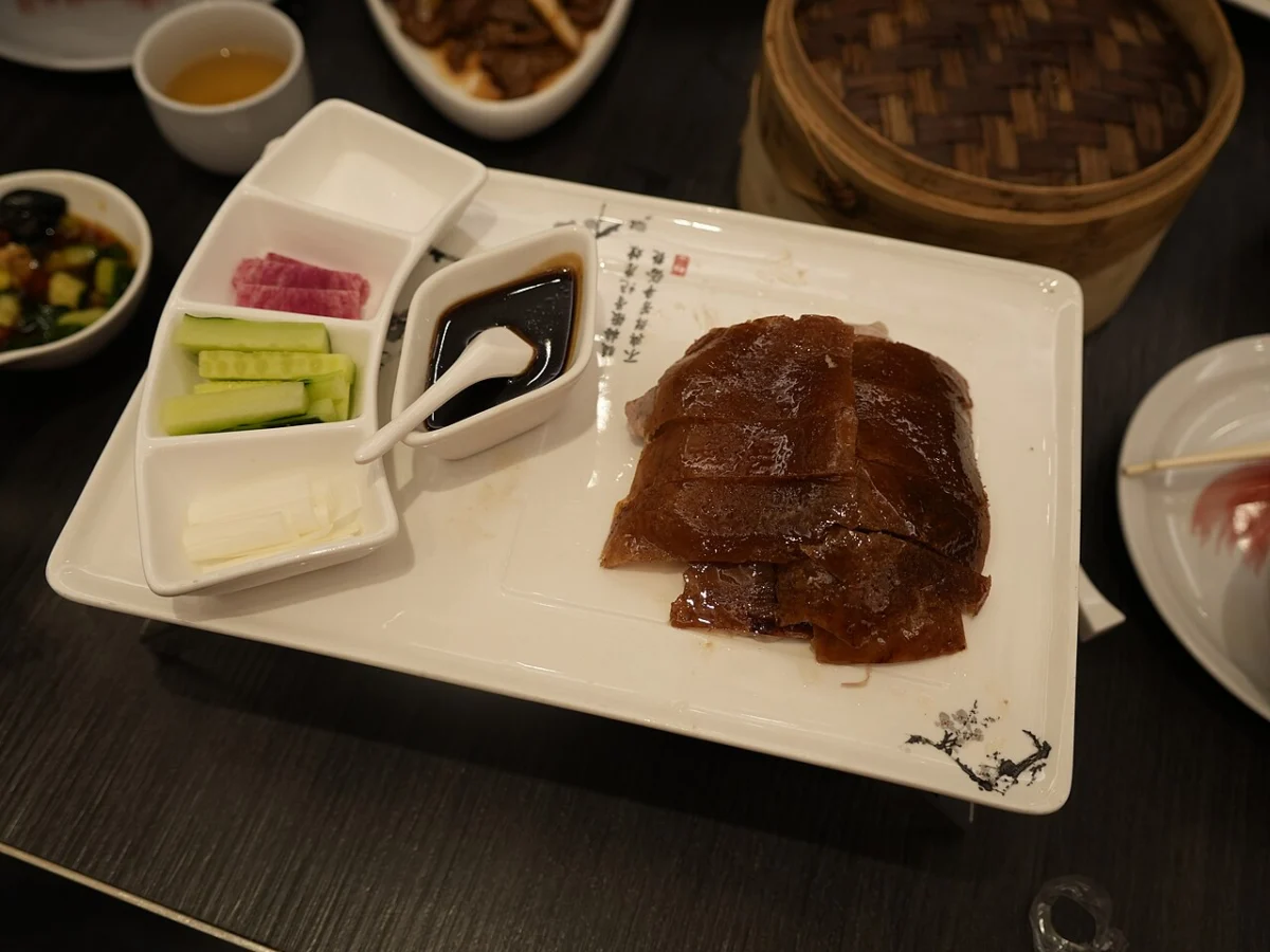 Fatias de pato assado servidas com acompanhamentos da cozinha chinesa