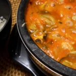 Ensopado coreano sundubu jjigae com tofu macio servido em tigela